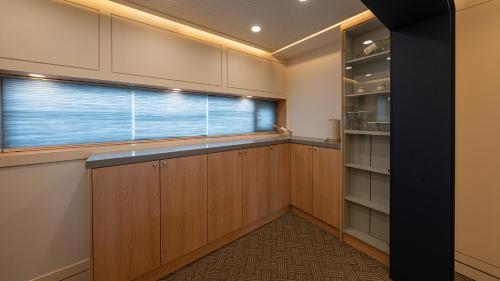 a kitchen with wooden cabinets and a window at Hwangridan Stay in Gyeongju