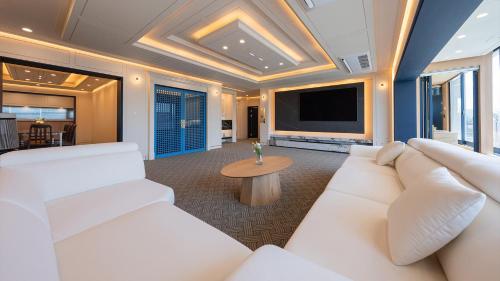 a living room with a white couch and a tv at Hwangridan Stay in Gyeongju