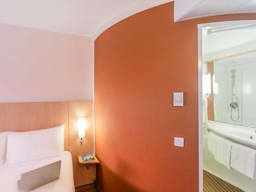 a hotel room with a bed and a bathroom at Hotel Ibis Lisboa Sintra in Sintra