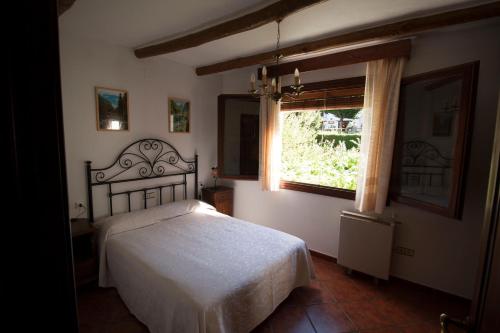 1 dormitorio con cama y ventana en Casa Loles, en Capileira