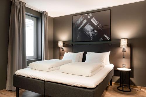 a bedroom with a large bed with white pillows at Scandic Vulkan in Oslo