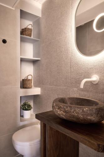 a bathroom with a sink and a toilet and a mirror at Kaitlyn's Residence in Mikonos