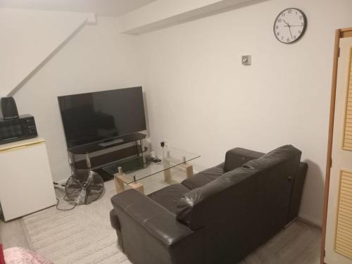 a living room with a couch and a tv at Modern Apartment in Southeast London in Plumstead