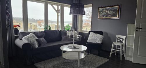 a living room with a blue couch and a table at Apartment in Hoviksnas, 300 m from the sea with a view of the Tjorn Bridge in Höviksnäs