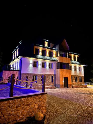 a large building is lit up at night at PEC 140 - apartmány Máj in Pec pod Sněžkou