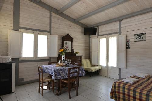 a dining room with a table and chairs and windows at Podere Badia Valdrago Agriturismo Mugello Circuit in Scarperia