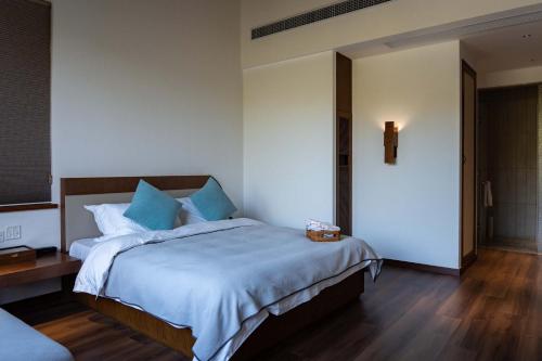 a bedroom with a large bed with blue pillows at Meijie Xiuju in Xinchating
