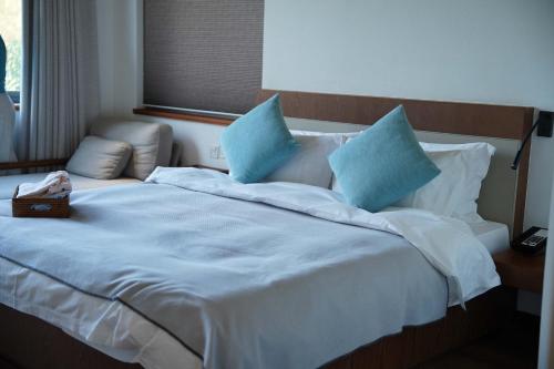 a woman laying on a bed with blue pillows at Meijie Xiuju in Xinchating