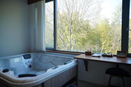 a bath tub in a bathroom with a large window at Meijie Xiuju in Xinchating