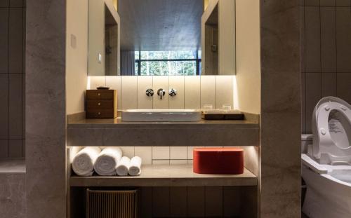 a bathroom with a sink and a toilet at Meijie Xiuju in Xinchating