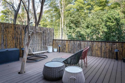 a deck with chairs and tables and a fence at Meijie Xiuju in Xinchating
