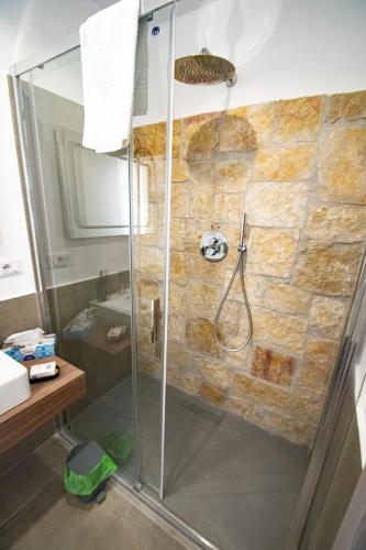 a shower with a glass door in a bathroom at my Vesta Suites in Vieste
