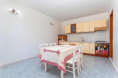 a kitchen with a table and chairs in a room at I Ciottoli Dello Ionio in Mascali