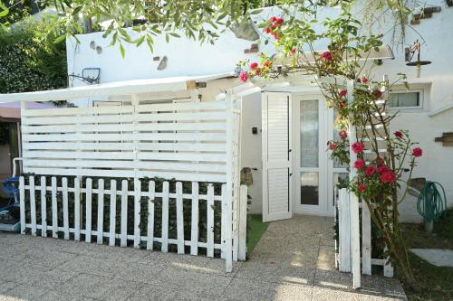 a white fence in front of a house with flowers at Podere Badia Valdrago Agriturismo Mugello Circuit in Scarperia