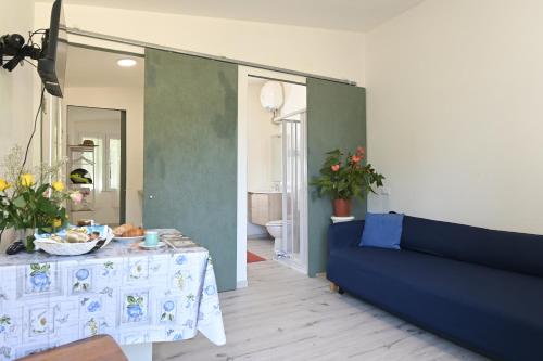 a living room with a blue couch and a table at Podere Badia Valdrago Agriturismo Mugello Circuit in Scarperia