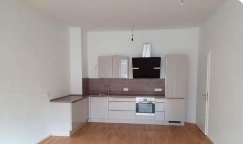 an empty kitchen with a stove and a microwave at Berlin -Central-Mitte Light Filled 2BD in Niederdorla