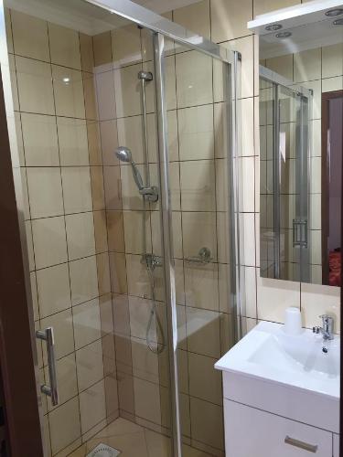 a shower with a glass door next to a sink at Ubytovanie Joli in Jovice