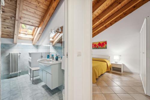 a bathroom with a bed and a sink in a room at Green Village Accommodations in Colico