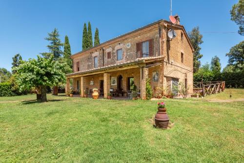 an old brick house on a grass field at Agriturismo Podere Marroneto in Monticiano