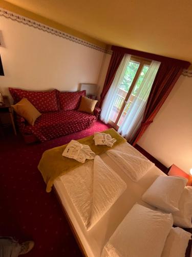 a bedroom with a large bed and a couch at Rauzi Hotel Garnì & apartments in Malè