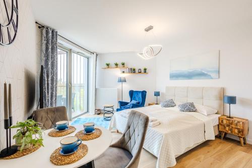 una camera da letto con un letto, un tavolo e delle sedie di Apartamenty PINEA tuż przy plaży a Pobierowo