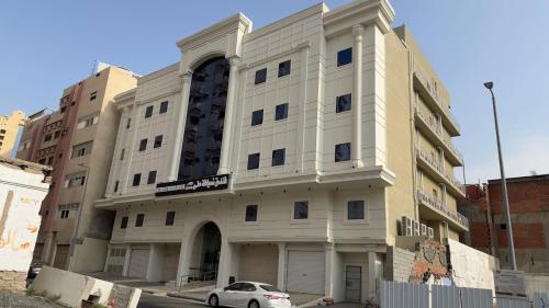 un edificio con un'auto parcheggiata di fronte di فندق ضيافة منى المشاعر الفندقية a Al Khansāk