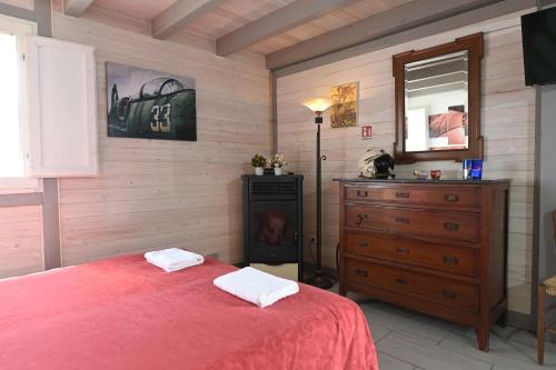 a bedroom with a bed and a dresser and a mirror at Podere Badia Valdrago Agriturismo Mugello Circuit in Scarperia