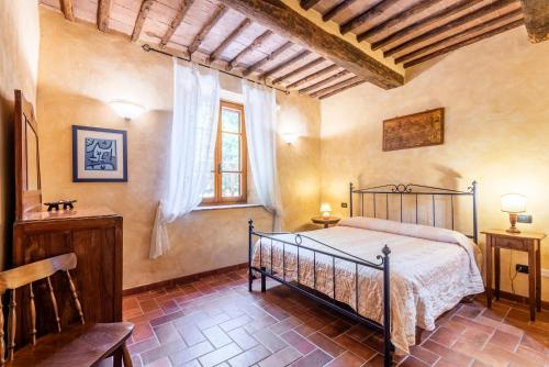 a bedroom with a bed and a window at Agriturismo Podere Marroneto in Monticiano