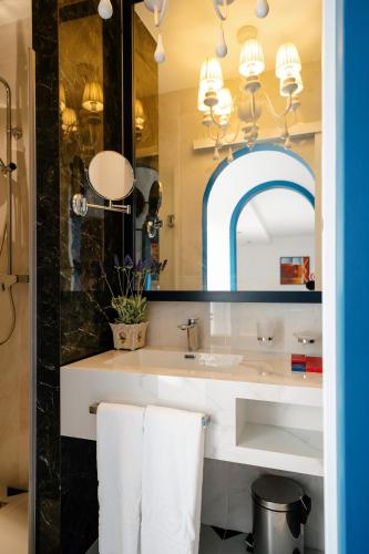 a bathroom with a sink and a mirror at Monicca Collection Suites and Residences in Albufeira