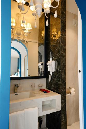 a bathroom with a sink and a mirror at Monicca Collection Suites and Residences in Albufeira