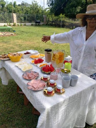 a woman standing next to a table with food on it at Dreamvilles Ecovillage Las Galeras in Las Galeras