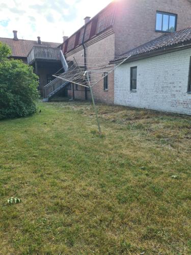 a pole in a yard next to a building at Gute Vingård in Havdhem