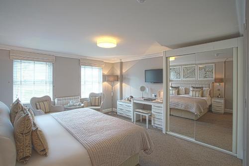 een slaapkamer met een bed en een bureau met een spiegel bij Hotel La Place in Saint Aubin