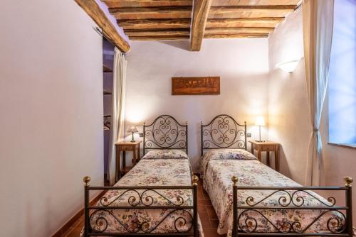 a bedroom with two beds and two tables at Agriturismo Podere Marroneto in Monticiano