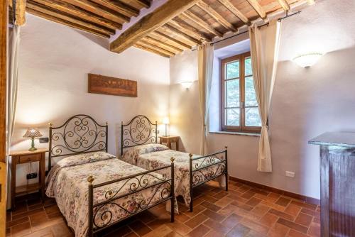 a bedroom with two beds and a window at Agriturismo Podere Marroneto in Monticiano