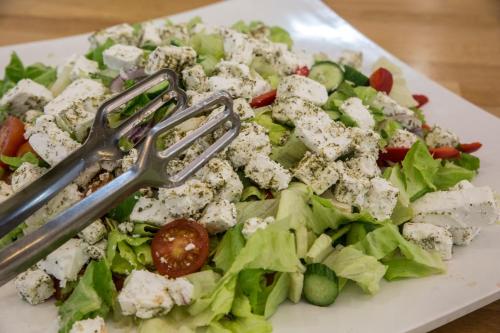 a salad with feta cheese on a plate with a fork at Astoria Galilee Hotel in Tiberias