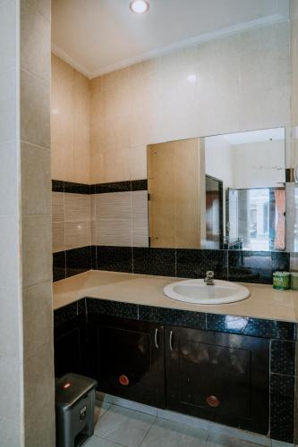 a bathroom with a sink and a mirror at Denays Guest House Jimbaran in Ngurah Rai International Airport