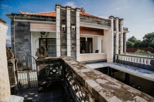 a house with a water fountain in front of it at Denays Guest House Jimbaran in Ngurah Rai International Airport