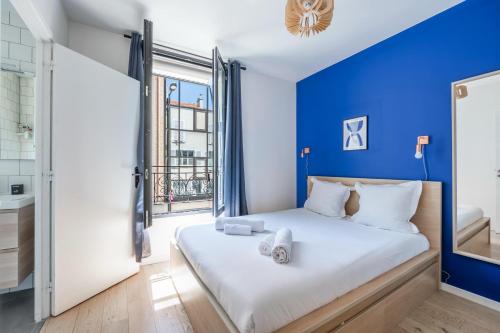 1 dormitorio con paredes azules y 1 cama con toallas. en City Center l 15min from Eiffel Tower by Car, en Boulogne-Billancourt