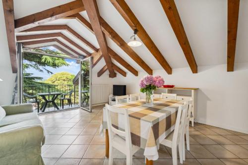 a dining room with a table and chairs and a couch at Green Village Accommodations in Colico