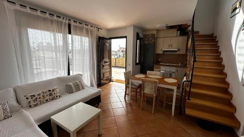 sala de estar con sofá, mesa y escalera en Wara House Fuerteventura, en La Oliva