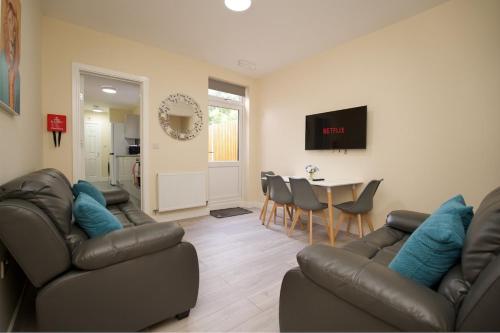 a living room with two couches and a dining room at Hastings Manor - Free Netflix, Parking, WiFi & Private Garden in Coventry