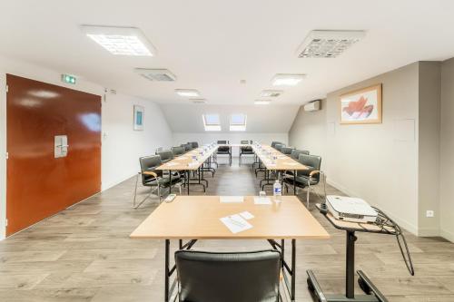 a large room with tables and chairs in it at Comfort Hotel Orleans Saran in Saran