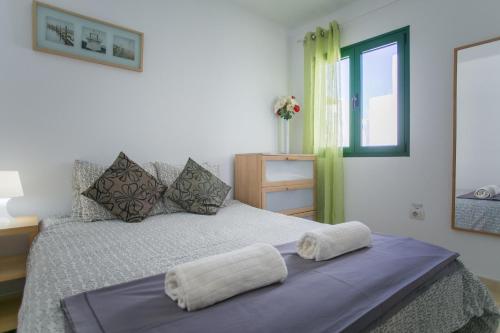 a bedroom with a bed with two towels on it at Lanzholidays in Tías