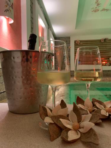 two glasses of wine and a flower on a table at Rauzi Hotel Garnì & apartments in Malè