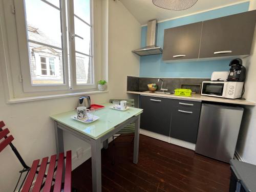 une petite cuisine avec une table et un micro-ondes dans l'établissement Entre Ciel et Quai Duplex avec vue, à Dieppe
