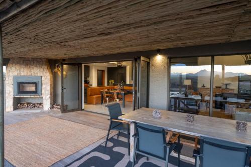 a dining area with a table and chairs and a fireplace at Gondwana Game Reserve in Kleinberg