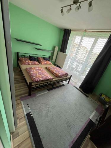Dos camas en una habitación con paredes verdes. en Útulný byt blízko centra, en Trenčín