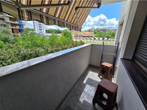 a balcony with two chairs and a view of a city at Stan na Dan Cazin in Ivišovo Greblje