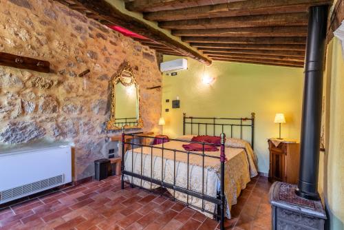 a bedroom with a bed and a stone wall at Agriturismo Podere Marroneto in Monticiano